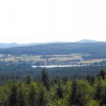 Neubäu mit See und Jugenberg im Hintergrund