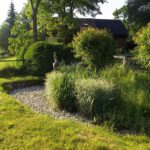 Grasensemble mit Skulptur