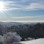 Die Sonne sinkt und färbt erste Wolken orange